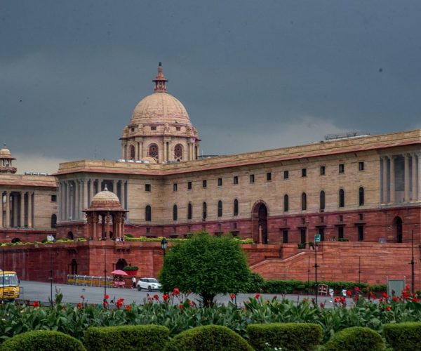 Grand sandstone building with columns and dome